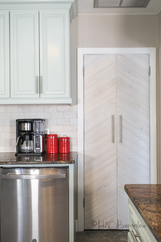 blue painted kitchen cabinets with DIY wood chevron door  