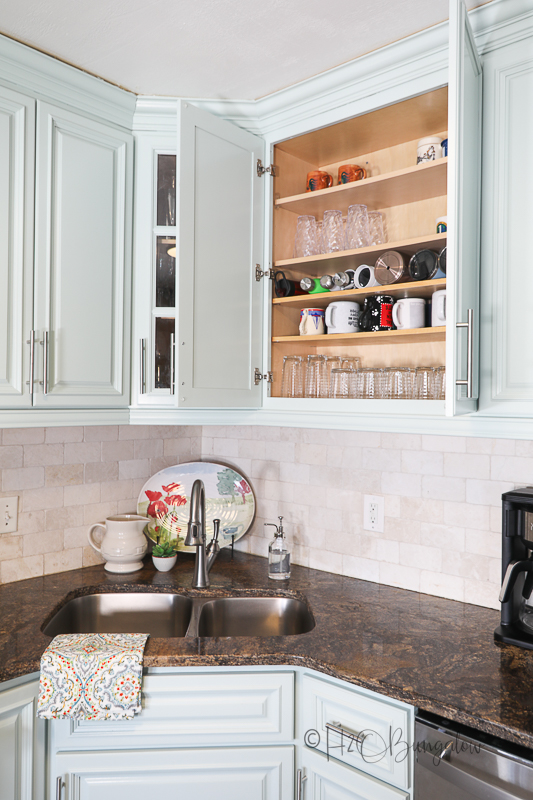 open blue painted cabinet door showing extra shelves for organizing inside