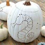 White pumpkin with sea horse design drilled into it.