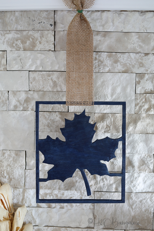 wood maple leaf cut out with burlap next to wreath