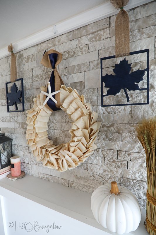 corn husk wreath hanging on stone fireplace mantel