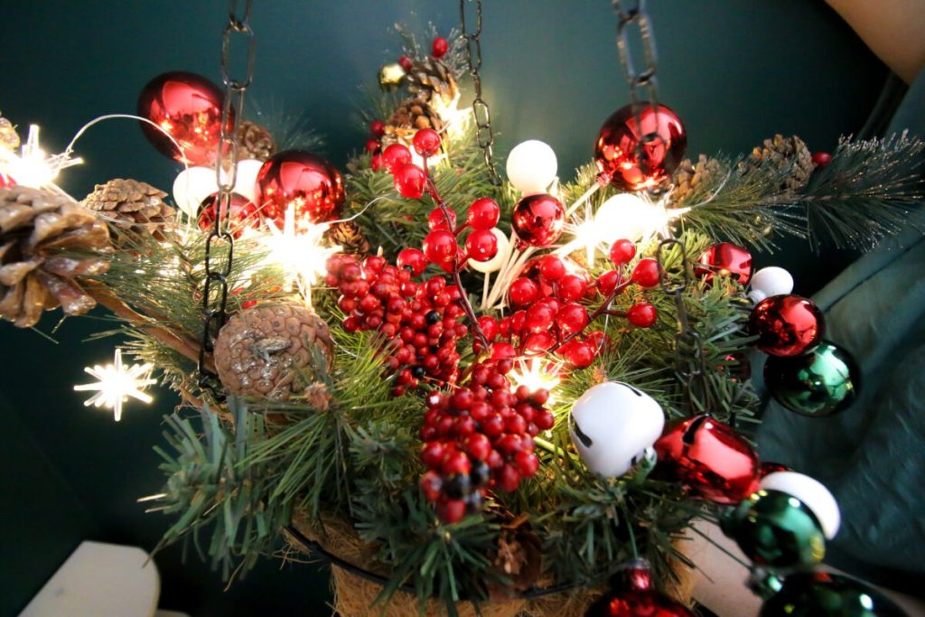 hanging basket with greenery, tree decorations and Christmas lights