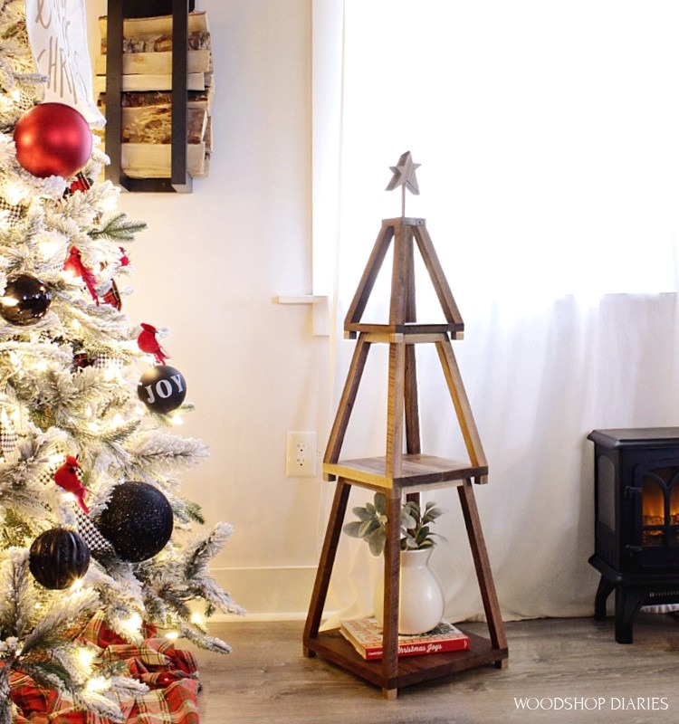 wooden Christmas tree tiered stand next to Christmas tree