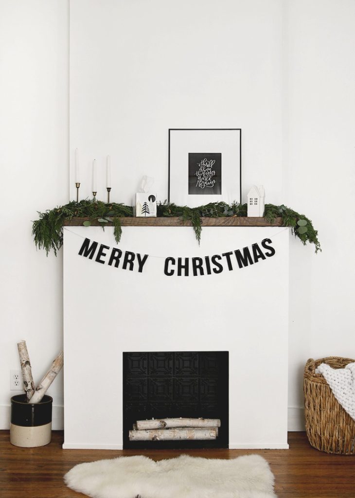 DIY Christmas decor garland spelling Merry Christmas hanging on fireplace