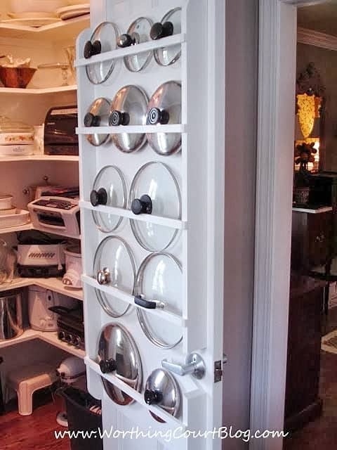 Pot and pan lids on organizing rack on pantry door